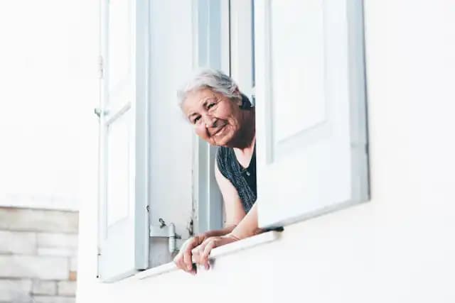 femme agée regardant par la fenêtre